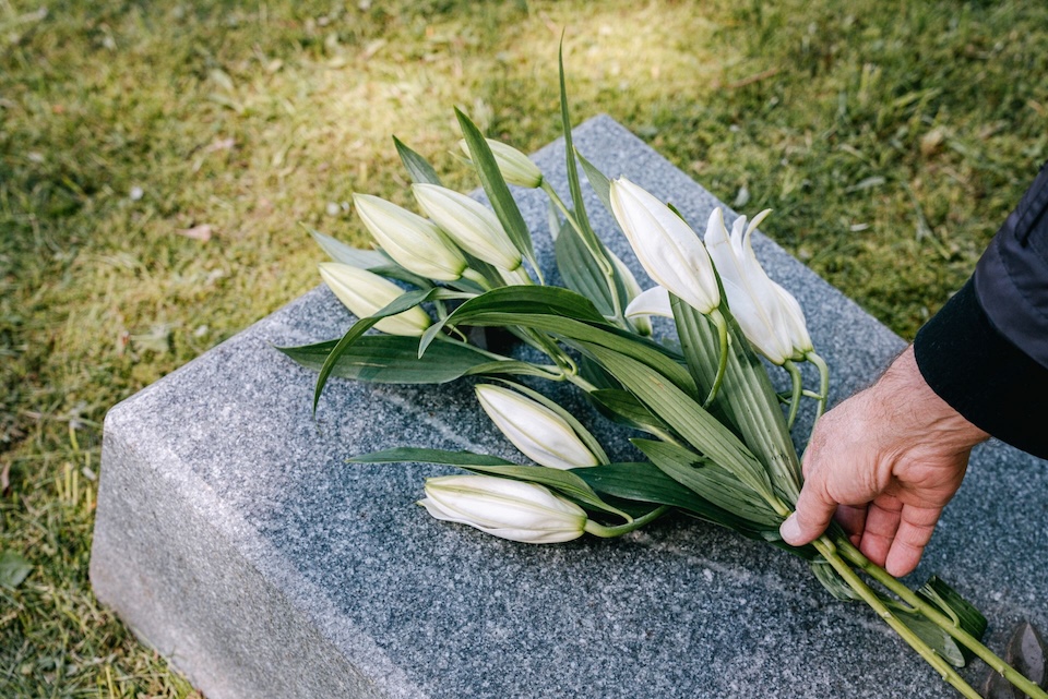 placing flowers on gravestone