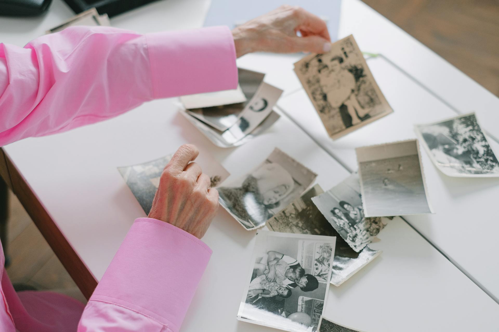 a woman sorting through old photos thinking about memories