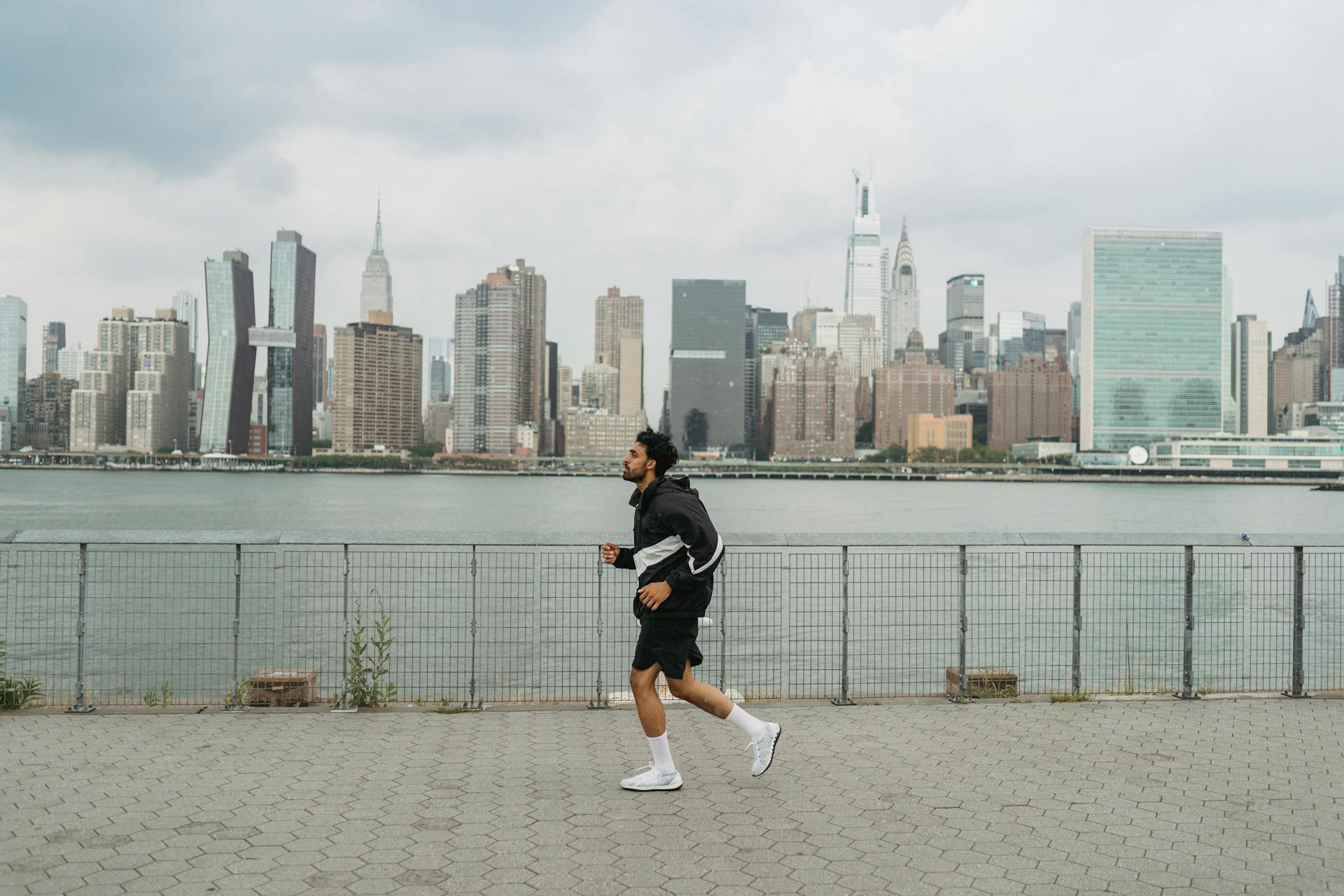 a man jogs alongside the water overlooking NYC
