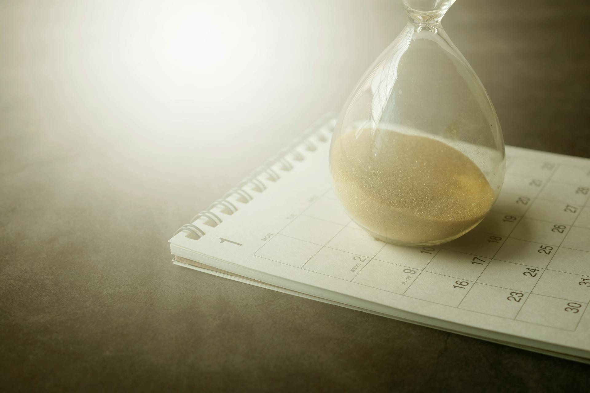 an hourglass resting on top of a calendar