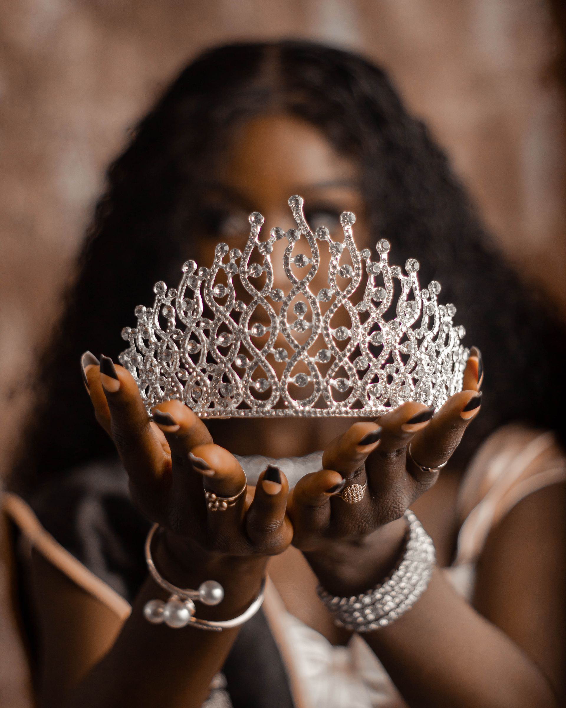 a woman holding a pageant crown