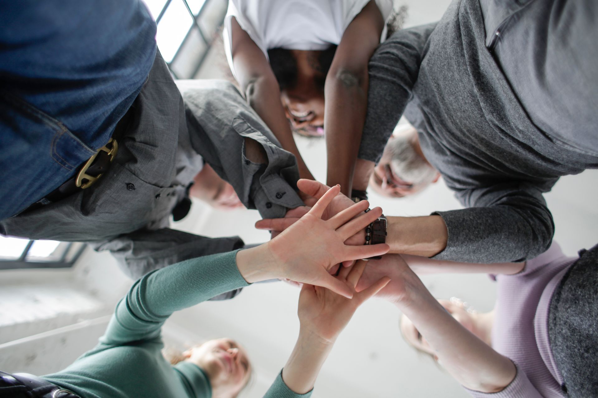 group of friends in a circle holding hands