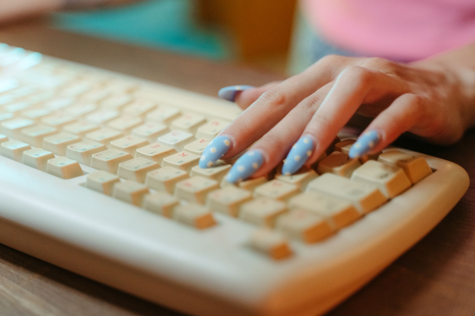 person with pretty nails types on a pretty keyboard
