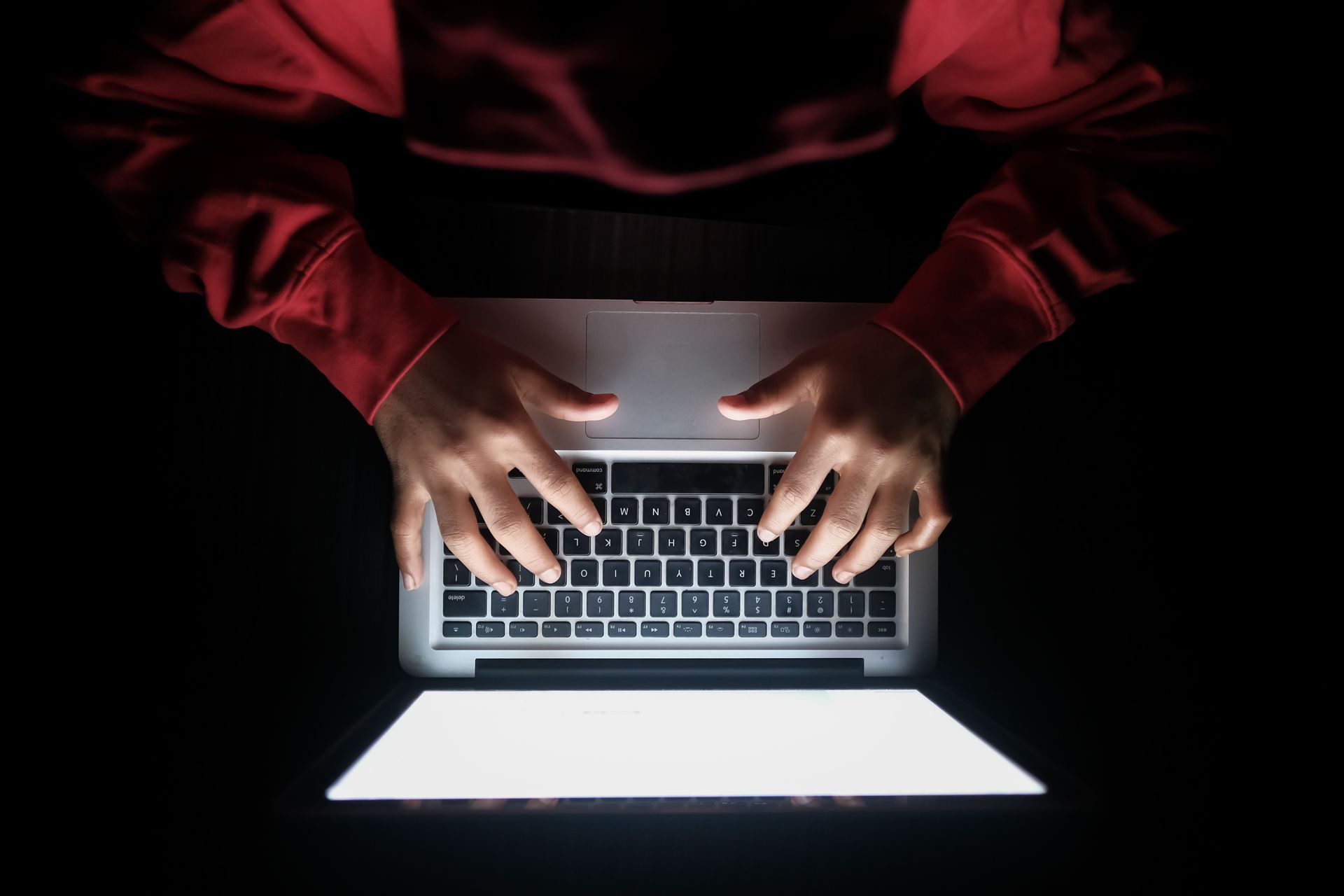 someone types sinisterly on a laptop
