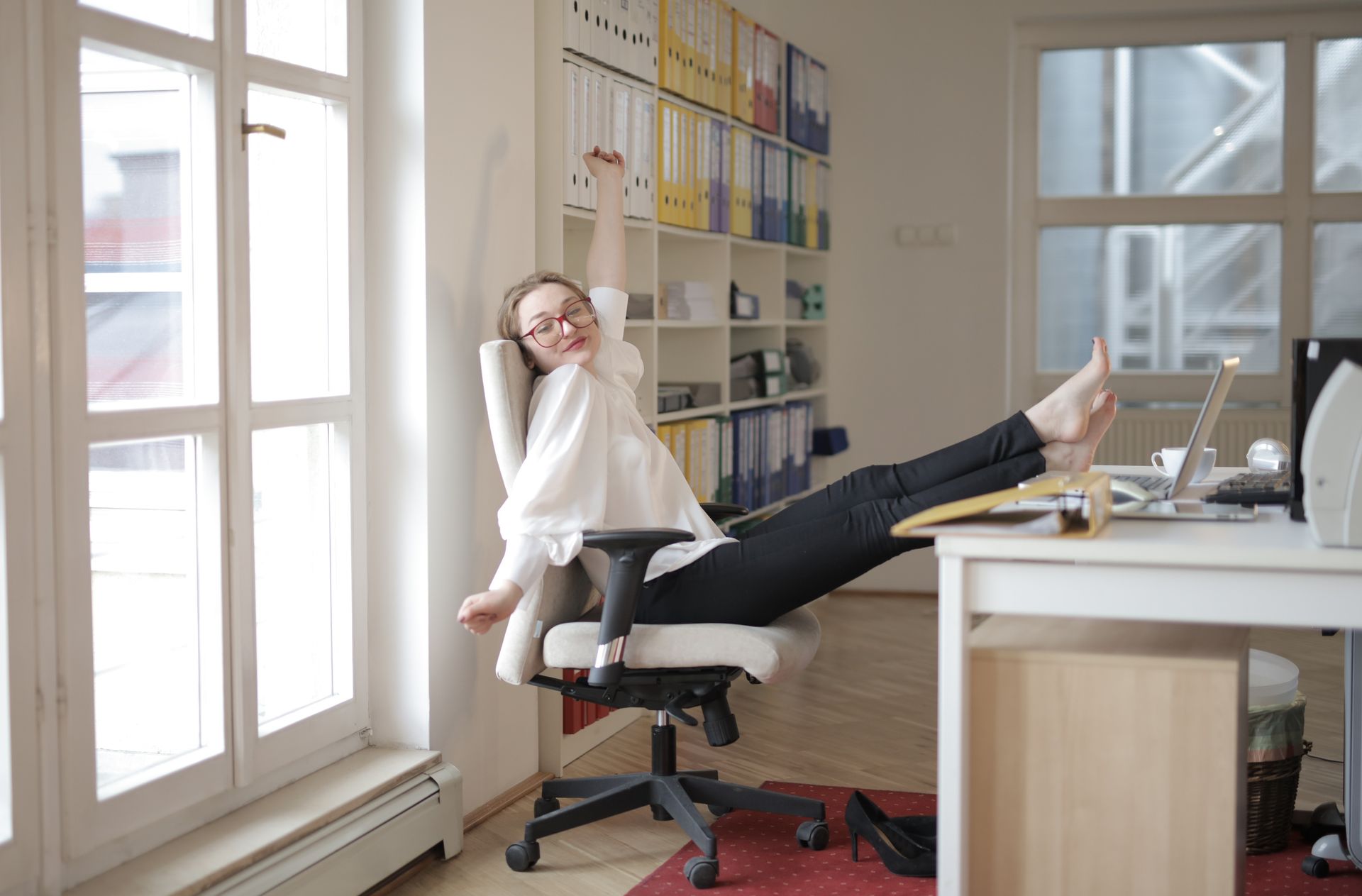 cheerful woman in a modern office celebrating her work