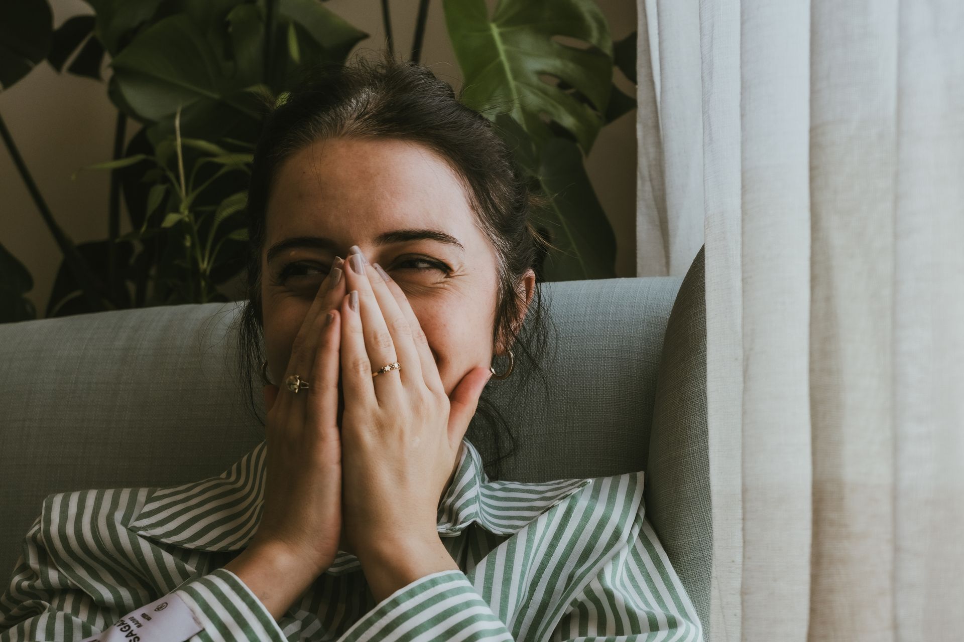 a woman covering her mouth laughing