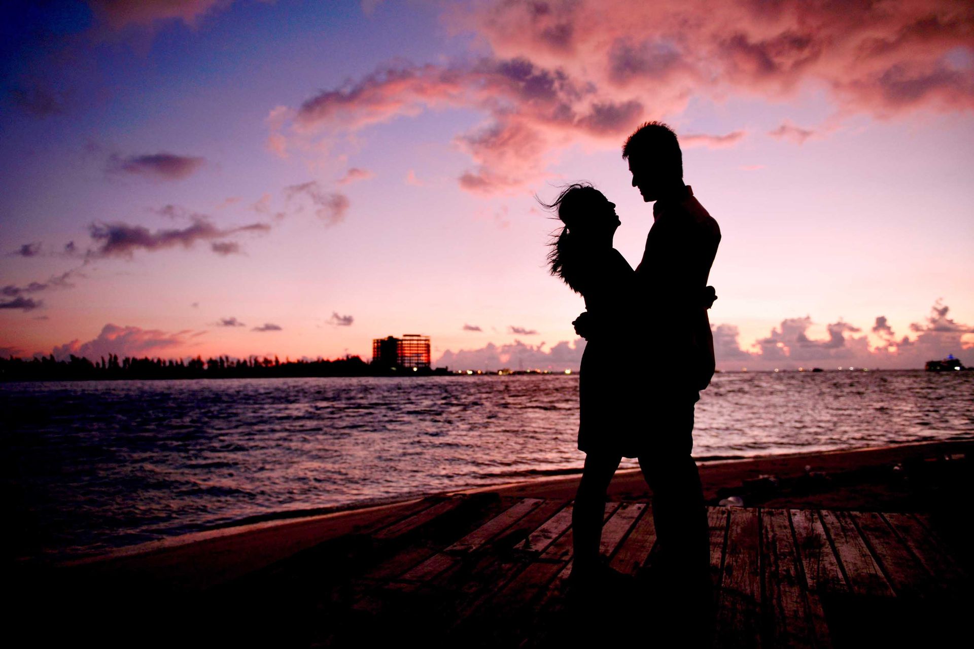 couple embracing silhouetted by the sun