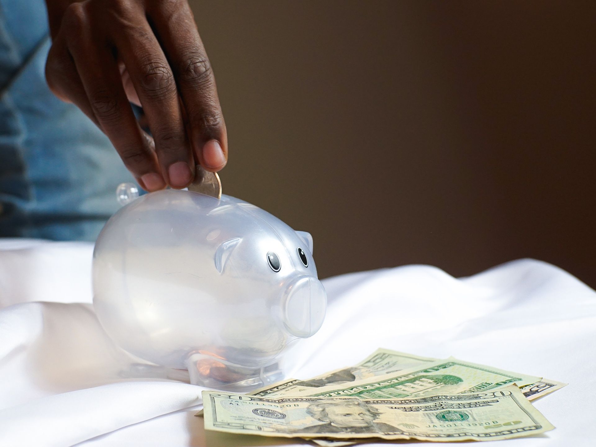 person putting coins into a piggy bank
