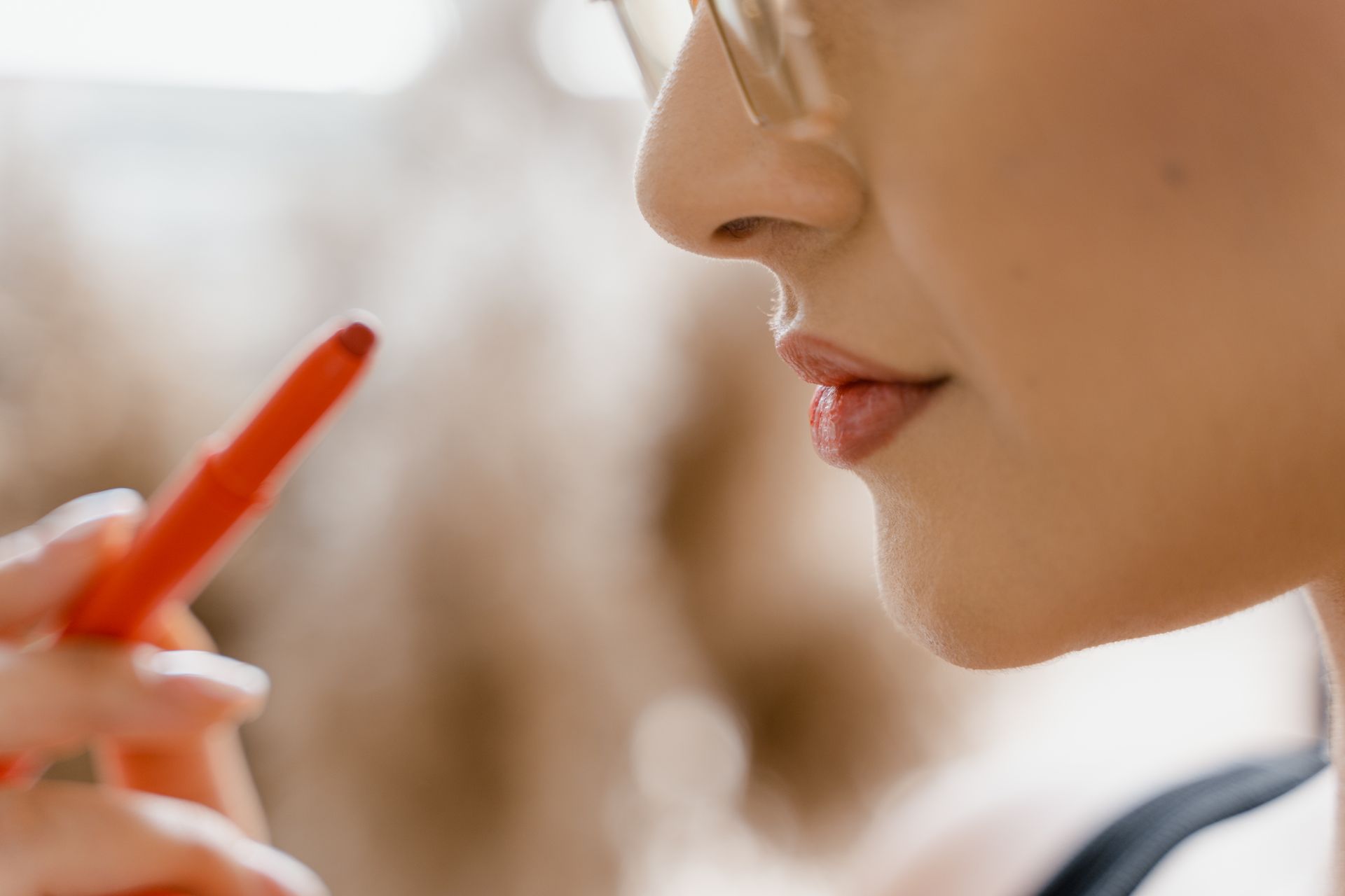 close up of a woman applying lipstick