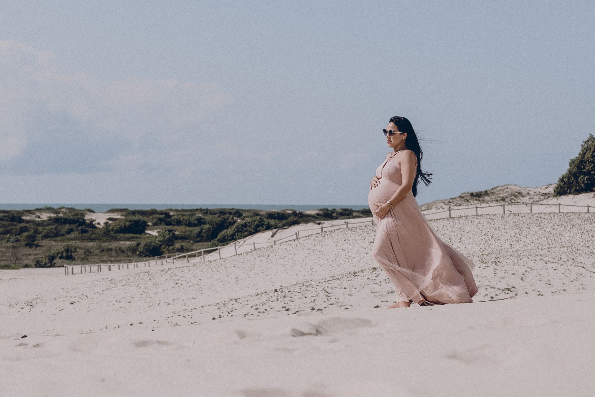pregnant woman walking on a beach