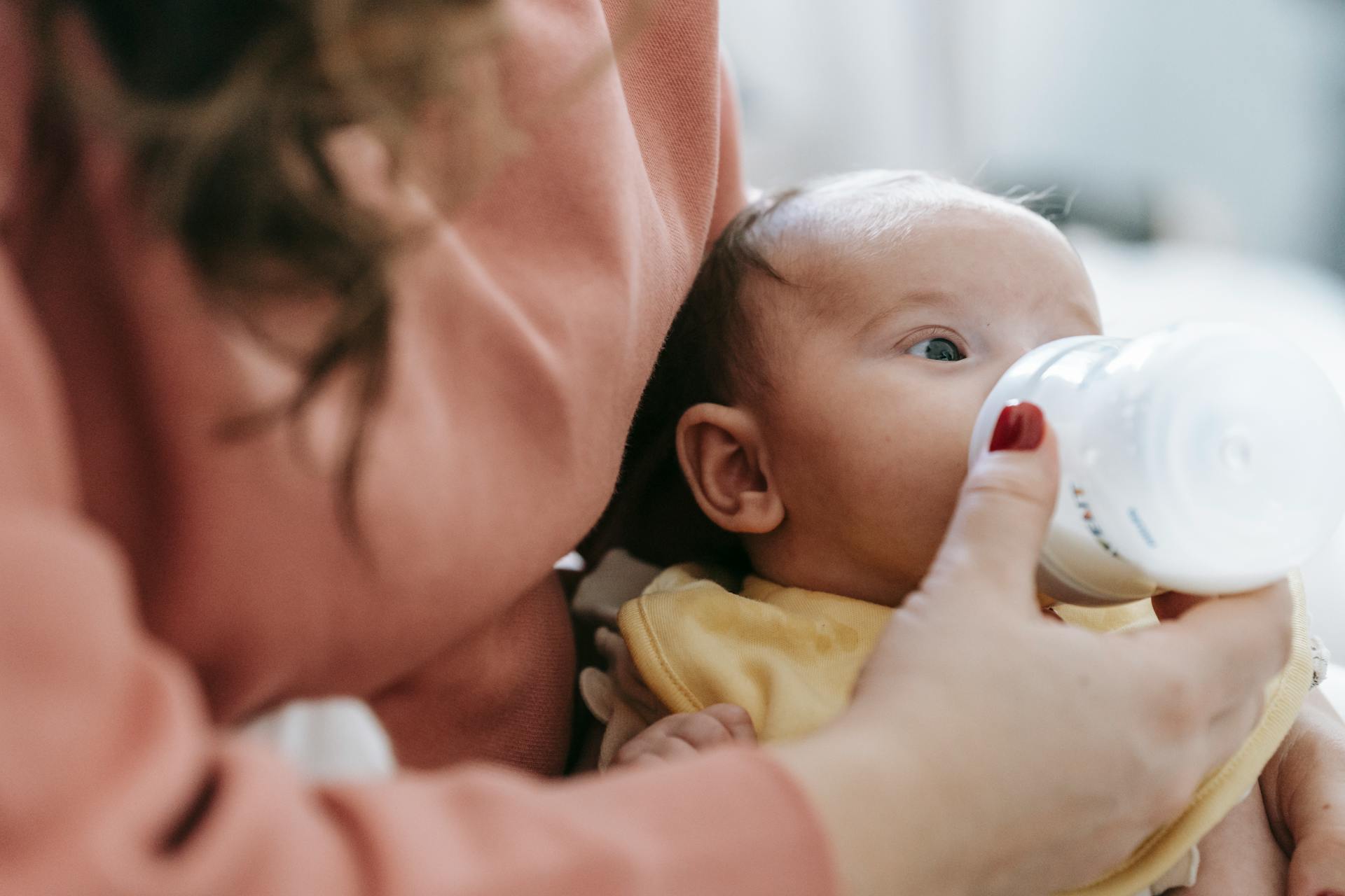 mother feeding baby with bottle