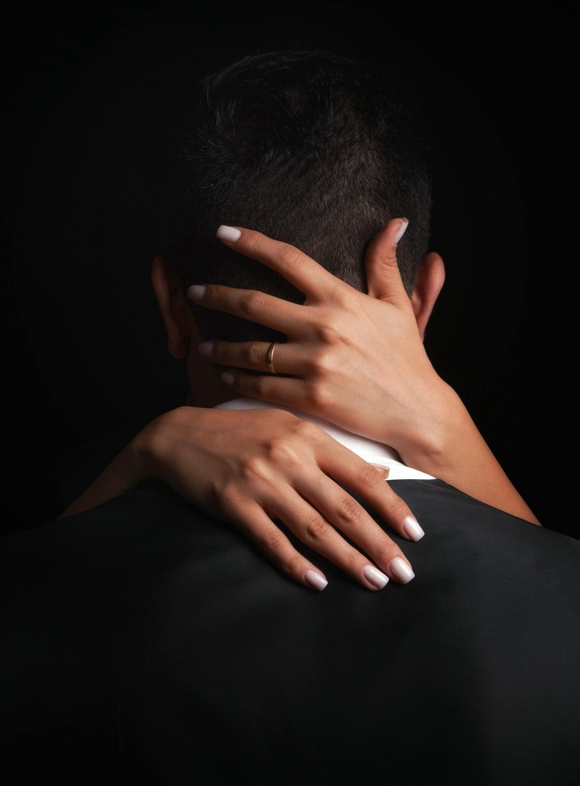 female hands wrapped around a mans heads