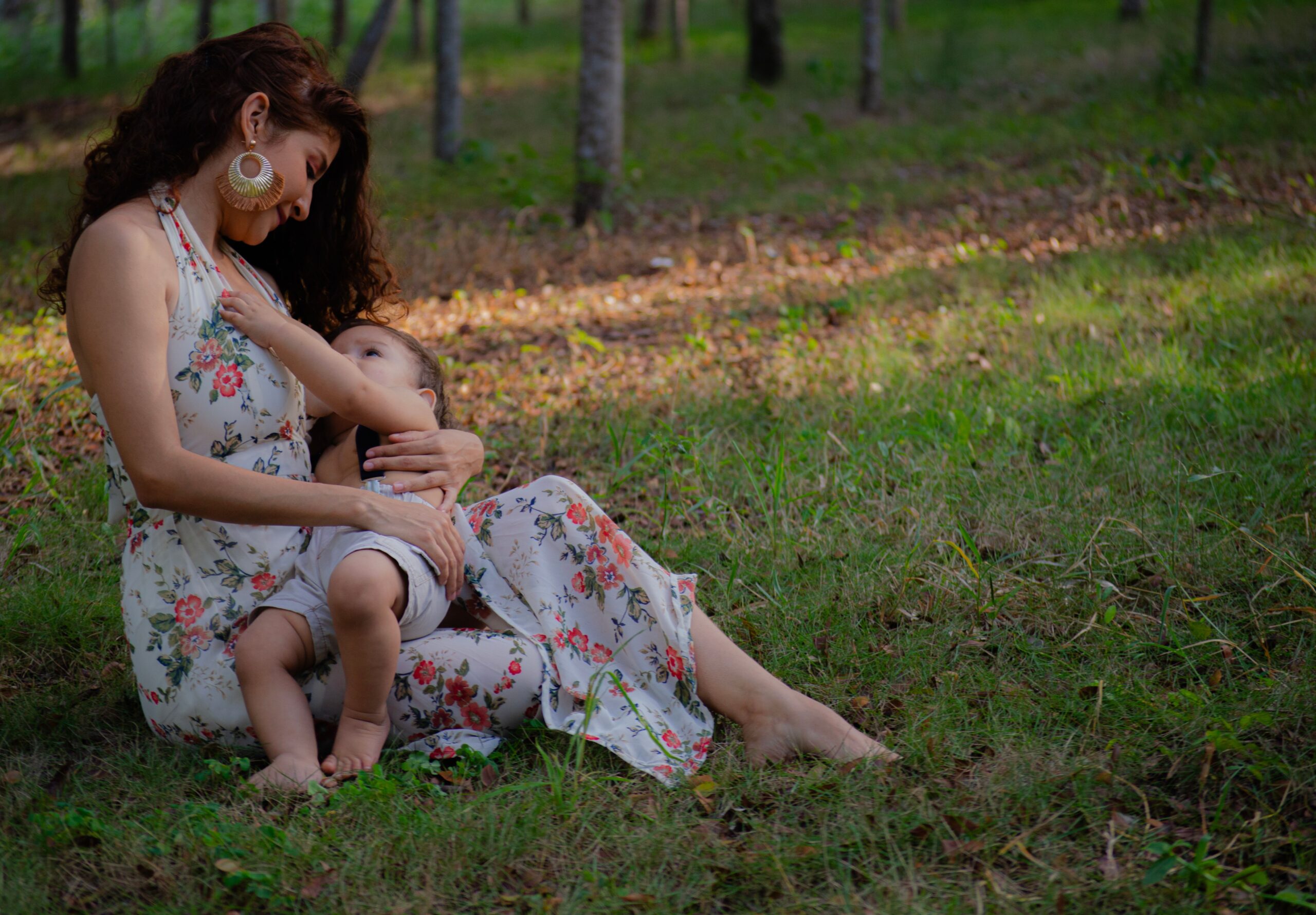 mom holding baby on grass