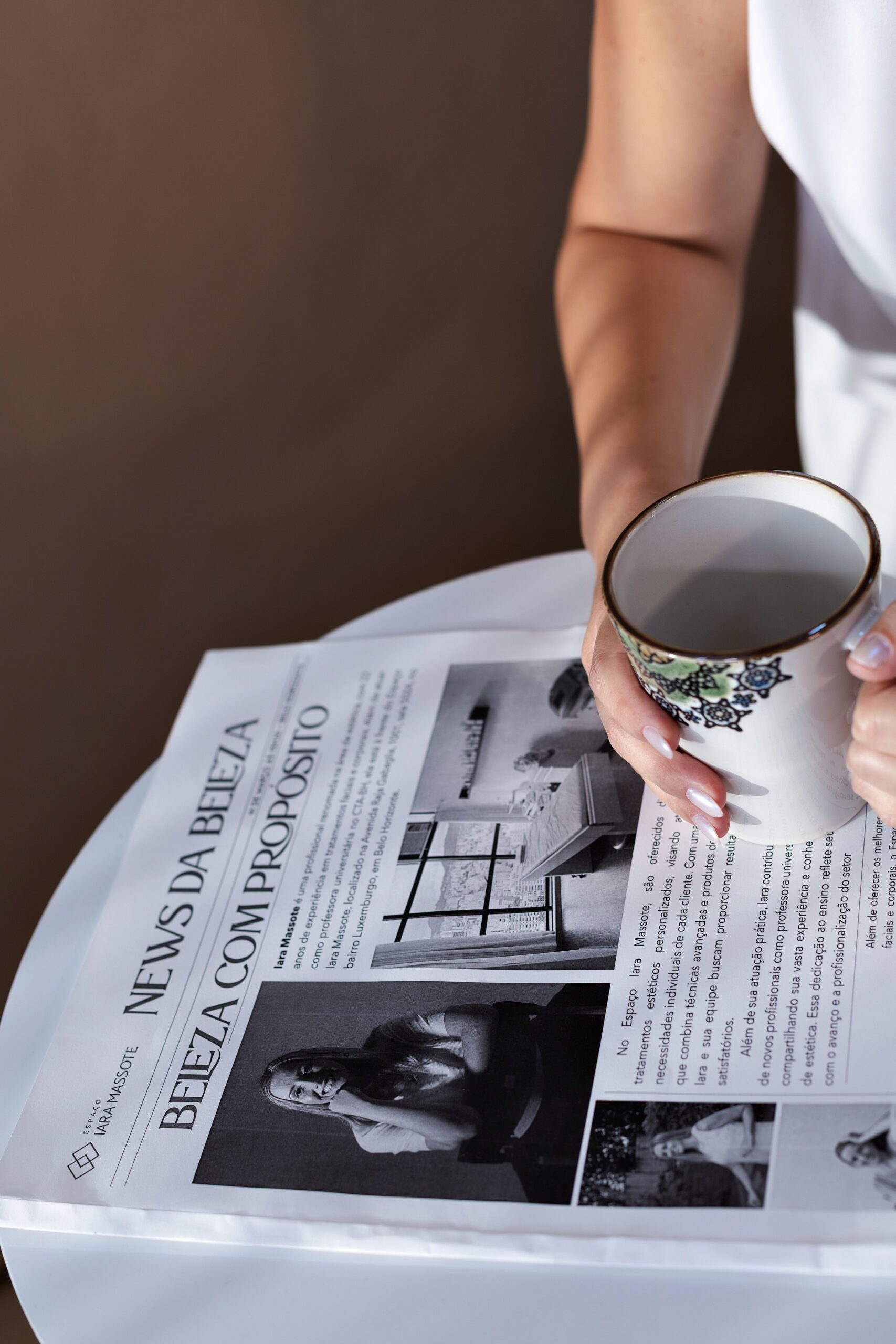 woman holding coffee with newspaper