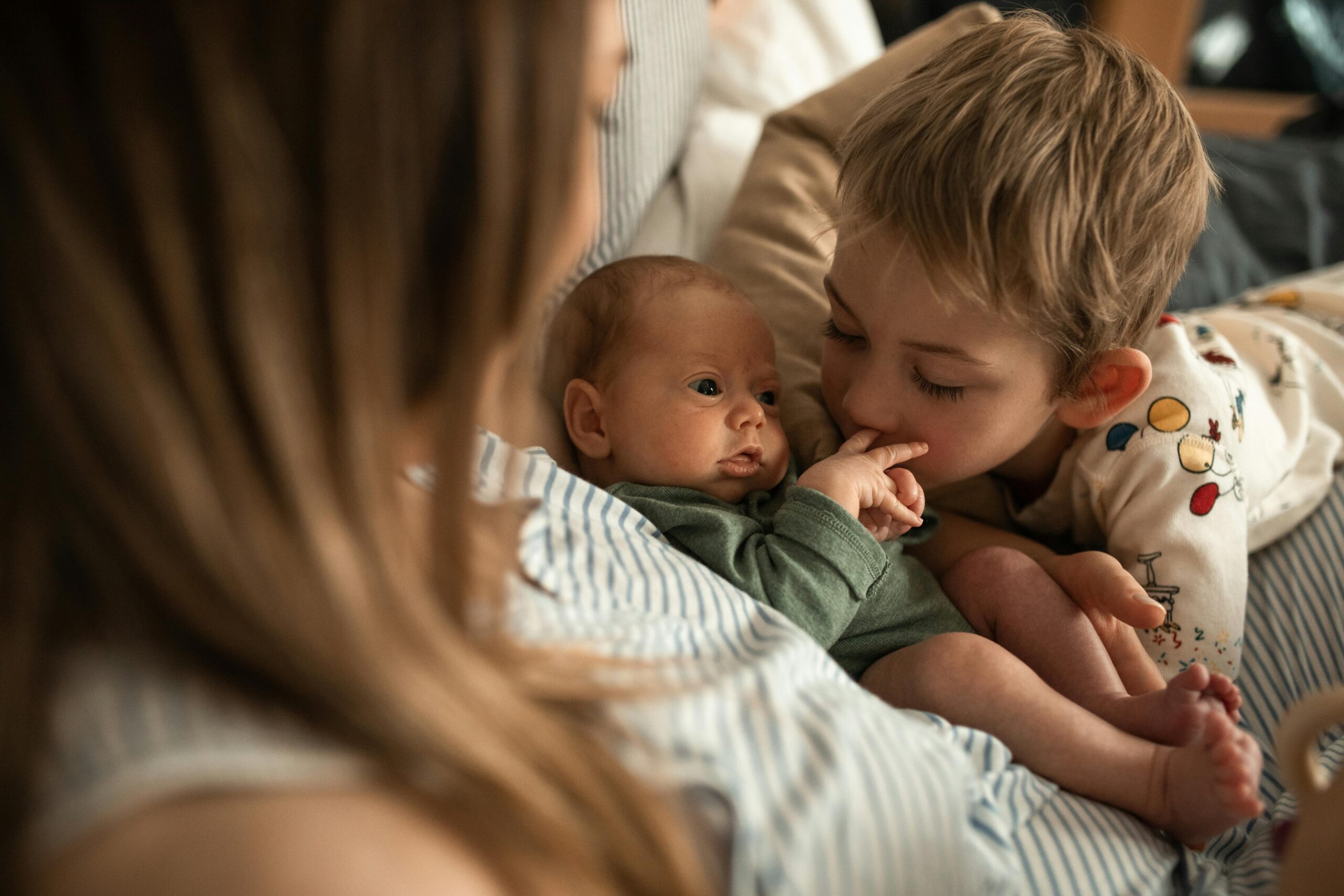 brother kissing new sibling