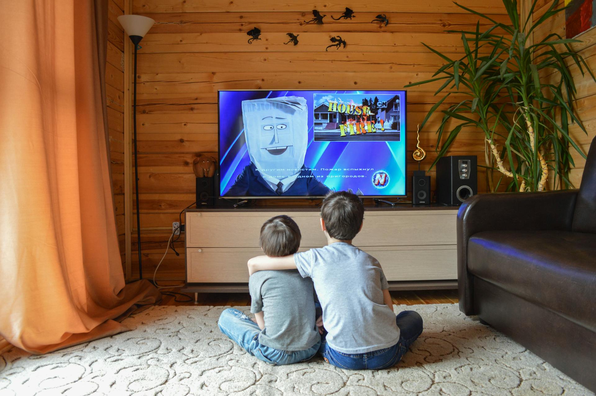 two kids sitting on the floor watching tv