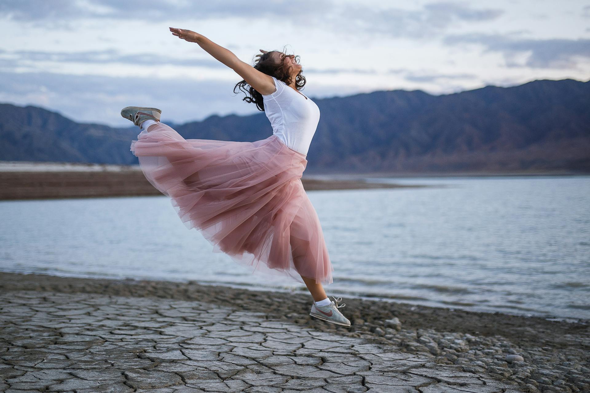 woman jumping on a beach happy to be alive