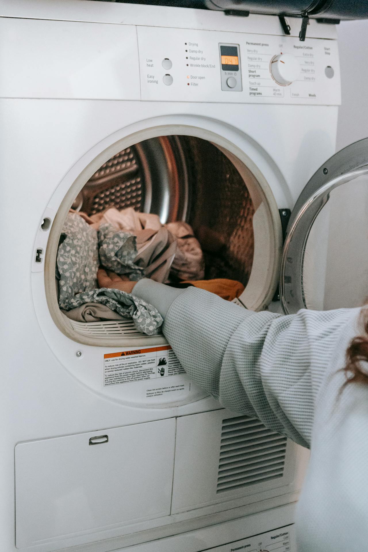 woman loading clothes in washing machine