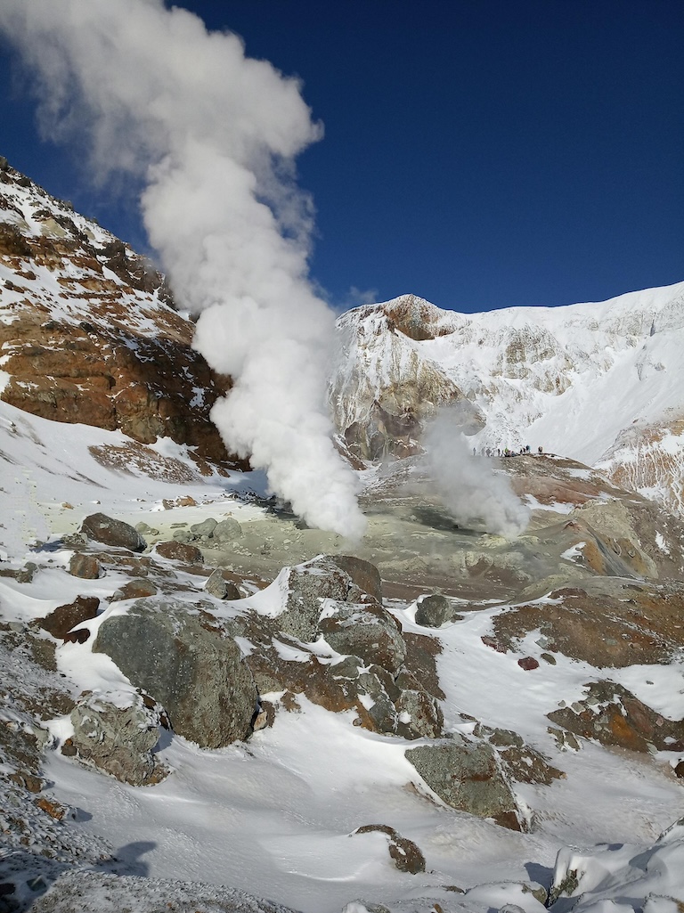 steam shooting out of a snow covered mountain