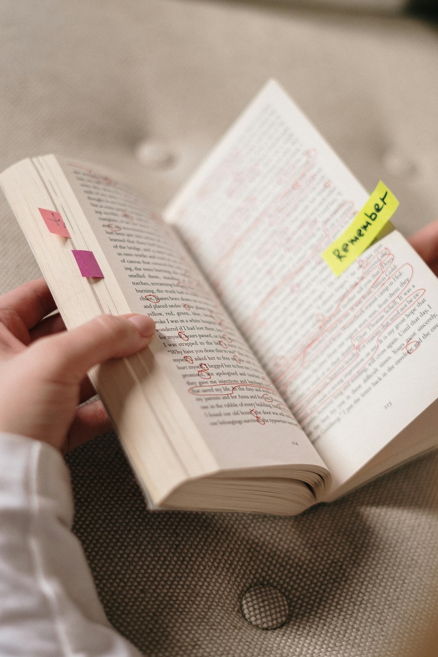 person holding a book with markups