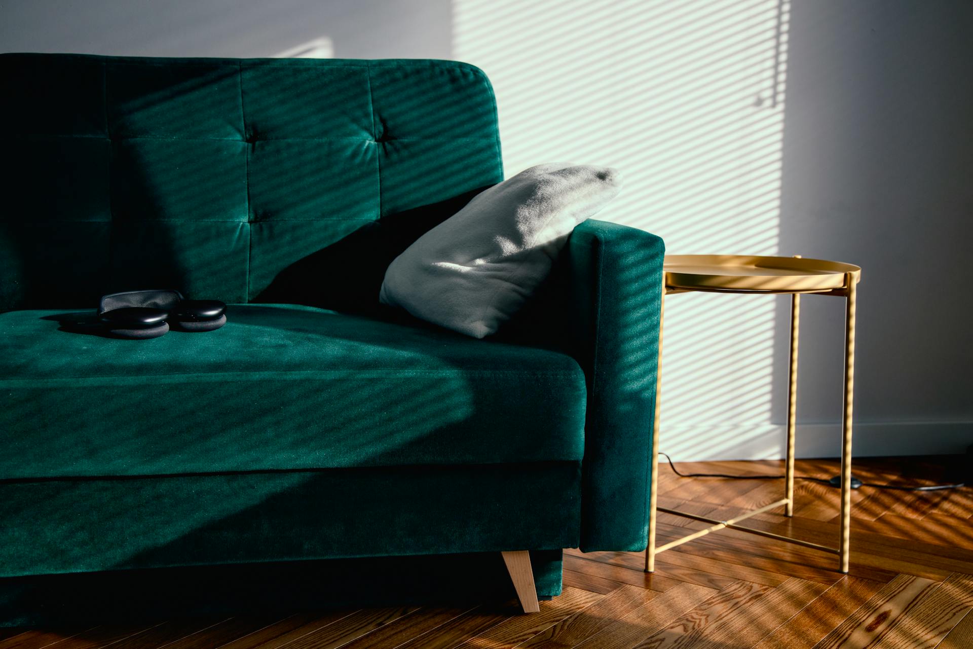 cozy minimalist sunlit room with green empty sofa and no clutter in site