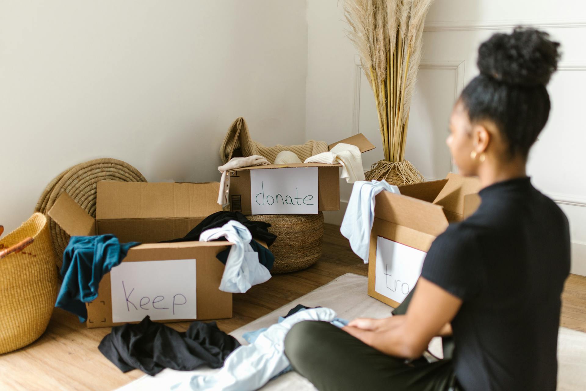 woman sitting in front of boxes organizing and decluttering